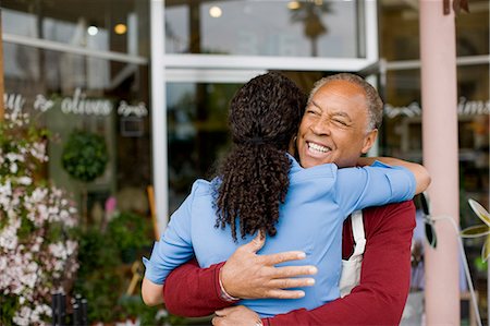 simsearch:6128-08747963,k - Man and woman hugging outside store Stock Photo - Premium Royalty-Free, Code: 6128-08747967