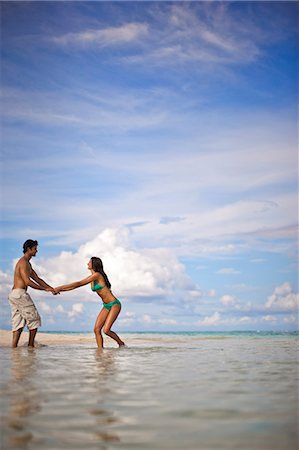 simsearch:6128-08747916,k - Happy young couple laughing and having fun playing together while wading at a tropical beach. Photographie de stock - Premium Libres de Droits, Code: 6128-08748017