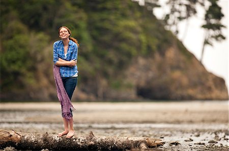 Cold teenage girl standing on log at the rocky beach. Stock Photo - Premium Royalty-Free, Code: 6128-08748142