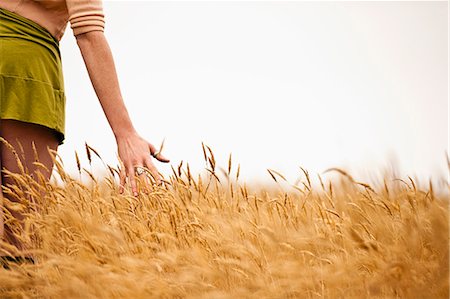 simsearch:400-07097368,k - Teenage girl running her hand through the field of wheat. Photographie de stock - Premium Libres de Droits, Code: 6128-08748145