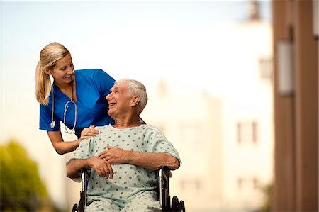 simsearch:6128-08780753,k - Young doctor and her elderly patient laughing together as she pushes him in a wheelchair. Stock Photo - Premium Royalty-Free, Code: 6128-08748167