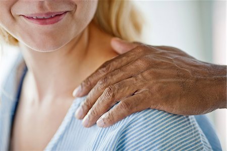 simsearch:6128-08748166,k - Female hospital patient smiling as she looks at the comforting hand laid on her shoulder. Photographie de stock - Premium Libres de Droits, Code: 6128-08748164