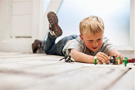 simsearch:6128-08747866,k - Boy playing with his toys on the floor. Foto de stock - Sin royalties Premium, Código: 6128-08748182