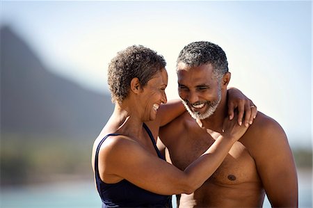 simsearch:6128-08798831,k - Mid adult couple standing with their arms around each other on a beach. Fotografie stock - Premium Royalty-Free, Codice: 6128-08748113