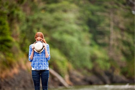 Teenage girl hiding behind her hat. Stock Photo - Premium Royalty-Free, Code: 6128-08748138