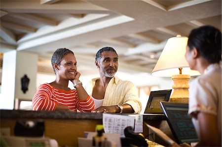 service man shoulder - Couple checking into their hotel. Stock Photo - Premium Royalty-Free, Code: 6128-08766548