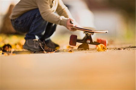 Man bending over holding skateboard. Stock Photo - Premium Royalty-Free, Code: 6128-08766585