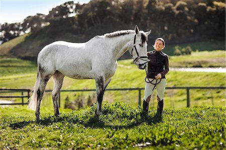 simsearch:6128-08738561,k - Mid adult woman standing with her horse in a green pasture. Stock Photo - Premium Royalty-Free, Code: 6128-08766775