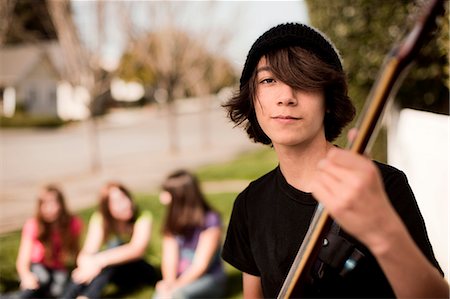 simsearch:6128-08737935,k - Teenage boy posing with his guitar while an audience watches behind him. Stock Photo - Premium Royalty-Free, Code: 6128-08766793