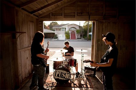 Three teenage boys playing instruments during band practice. Photographie de stock - Premium Libres de Droits, Code: 6128-08766796