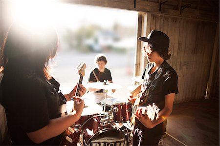 playing guitar and drums - Three teenage boys playing instruments during band practice. Stock Photo - Premium Royalty-Free, Code: 6128-08766798