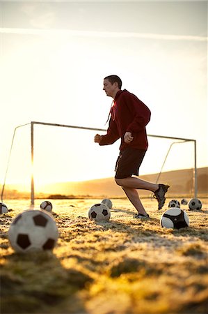 soccer ball sneaker - Jogger running across a soccer field. Stock Photo - Premium Royalty-Free, Code: 6128-08766892
