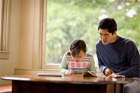 simsearch:6128-08767321,k - Father helping his daughter with her homework. Foto de stock - Royalty Free Premium, Número: 6128-08766945