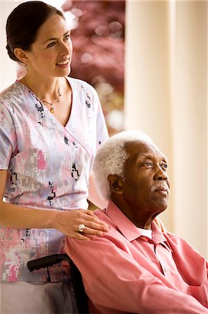 Smiling nurse puts supportive hand on a senior man's shoulders as he sits in a wheelchair on a porch. Stock Photo - Premium Royalty-Free, Code: 6128-08766936