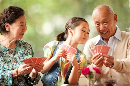 simsearch:6128-08780428,k - Senior couple playing cards with their granddaughter. Fotografie stock - Premium Royalty-Free, Codice: 6128-08767010