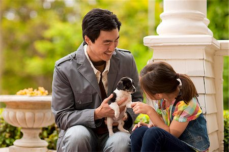 simsearch:6128-08737856,k - Portrait of father and daughter playing with a puppy. Photographie de stock - Premium Libres de Droits, Code: 6128-08767015