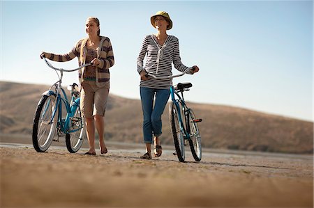 Mother and daughter walking their bikes on a beach. Stock Photo - Premium Royalty-Free, Code: 6128-08767170