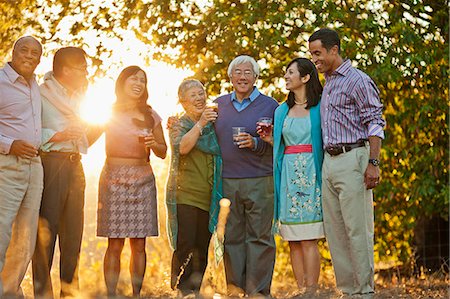 simsearch:632-05816609,k - Smiling group of friends celebrating with drinks in a back yard. Foto de stock - Sin royalties Premium, Código: 6128-08767185