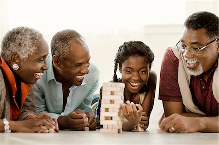 Smiling multi generational family playing a block removal game. Stock Photo - Premium Royalty-Free, Code: 6128-08767259