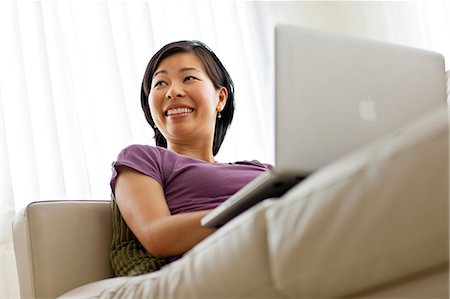 Happy young woman using a laptop computer. Stock Photo - Premium Royalty-Free, Code: 6128-08767269