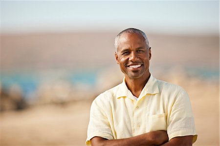 simsearch:6128-08781051,k - Portrait of a smiling man standing on a beach. Foto de stock - Royalty Free Premium, Número: 6128-08767214