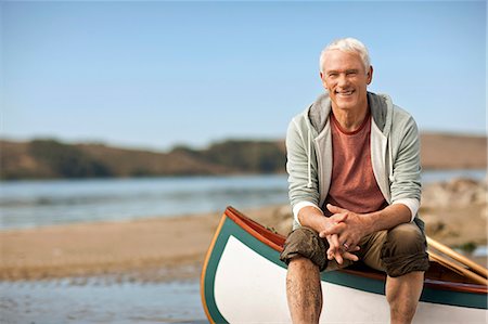 simsearch:832-03640492,k - Portrait of a smiling senior man sitting on the edge of a canoe. Fotografie stock - Premium Royalty-Free, Codice: 6128-08767239