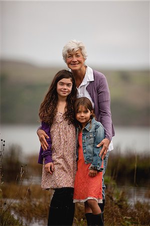 simsearch:614-06336315,k - Smiling grandmother hugs her two granddaughters as they pose for a portrait outside. Stock Photo - Premium Royalty-Free, Code: 6128-08767313