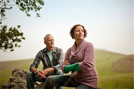 pensive mature brunette woman looking away - Middle aged couple sitting together on a rock in a rural field. Stock Photo - Premium Royalty-Free, Code: 6128-08767311