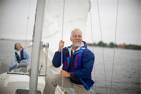 friends sailing - Senior adult man hoisting the mainsail of a boat. Stock Photo - Premium Royalty-Free, Code: 6128-08780371