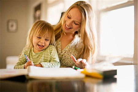 Young girl playing with a coloring book with her mother. Photographie de stock - Premium Libres de Droits, Code: 6128-08780579