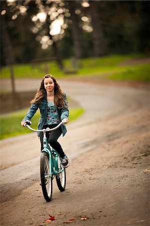 simsearch:6128-08738599,k - Teenage girl riding as bicycle on a rural road. Foto de stock - Royalty Free Premium, Número: 6128-08780583