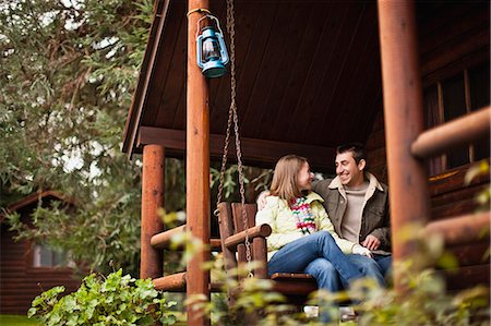 swing bench - Young couple happily sitting on bench swing together. Stock Photo - Premium Royalty-Free, Code: 6128-08780585