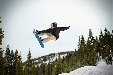simsearch:693-03707249,k - Young man jumping mid-air while riding his snowboard  outdoors in the snow. Foto de stock - Sin royalties Premium, Código: 6128-08780519