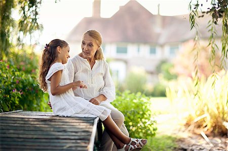 parent daughter warm talk - Young girl sits on a footbridge talking to her grandmother. Stock Photo - Premium Royalty-Free, Code: 6128-08780650