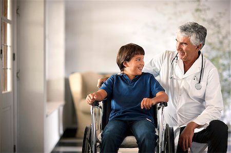 simsearch:6128-08738322,k - Young boy in a wheelchair talking to his doctor. Photographie de stock - Premium Libres de Droits, Code: 6128-08780694