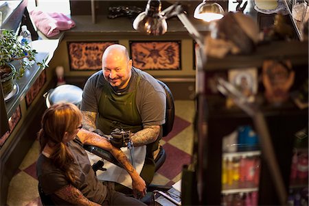 simsearch:400-03920996,k - Woman getting her arm tattooed at a tattoo parlour. Photographie de stock - Premium Libres de Droits, Code: 6128-08780614