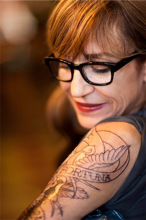 Portrait of woman with a fresh tattoo on her arm. Stockbilder - Premium RF Lizenzfrei, Bildnummer: 6128-08780615