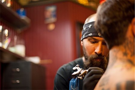 simsearch:400-03920996,k - Man getting a tattoo at a tattoo parlour. Photographie de stock - Premium Libres de Droits, Code: 6128-08780616