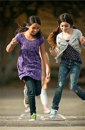 Two friends playing hopscotch. Stock Photo - Premium Royalty-Free, Code: 6128-08780621