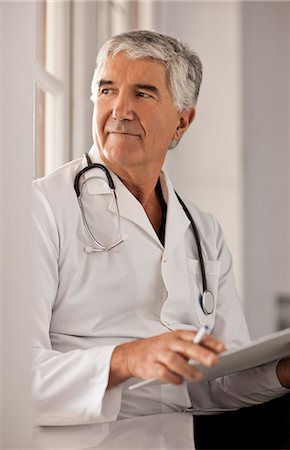 simsearch:6128-08780753,k - Male doctor thinking about the notes in someones file. Stock Photo - Premium Royalty-Free, Code: 6128-08780752