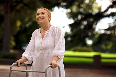 simsearch:6128-08780963,k - Elderly woman using a walker outdoors. Fotografie stock - Premium Royalty-Free, Codice: 6128-08780779