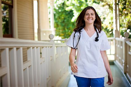 selective focus deck - Smiling nurse walking on the porch of rest-home. Stock Photo - Premium Royalty-Free, Code: 6128-08780949