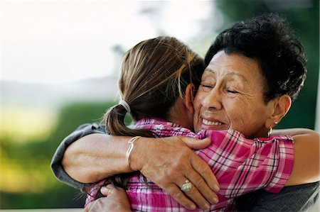 Senior woman receiving a hug from her granddaughter. Stock Photo - Premium Royalty-Free, Code: 6128-08780959