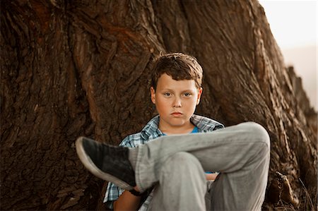 simsearch:6128-08780963,k - Portrait of boy sitting under the tree. Fotografie stock - Premium Royalty-Free, Codice: 6128-08780965