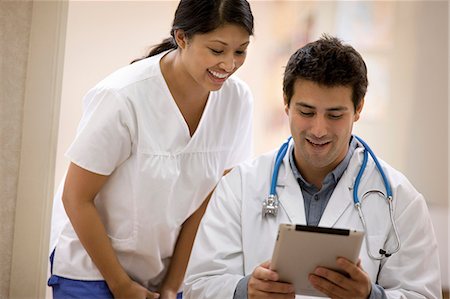 simsearch:6128-08780753,k - Young female nurse discussing notes with a doctor. Stock Photo - Premium Royalty-Free, Code: 6128-08780985