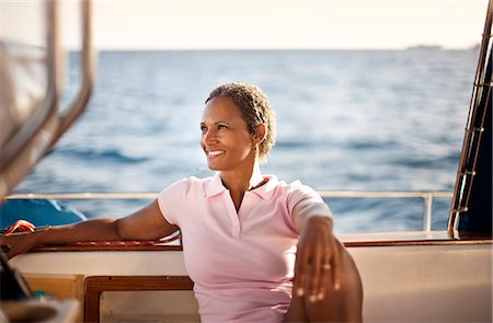 Mature woman leaning back relaxing on boat, looking at view. Foto de stock - Sin royalties Premium, Código: 6128-08780930