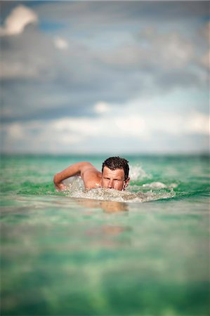 Focused middle aged man swimming the front crawl in the ocean. Stock Photo - Premium Royalty-Free, Code: 6128-08798796
