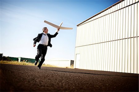 run suit low angle - A man playing with a model airplane Stock Photo - Premium Royalty-Free, Code: 6128-08798897