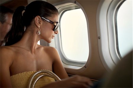 flight cabin - Content young woman looking out an airplane window. Stock Photo - Premium Royalty-Free, Code: 6128-08798809