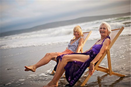 simsearch:6128-08798929,k - Two happy mature women relaxing in deck chairs on the beach. Stock Photo - Premium Royalty-Free, Code: 6128-08798940